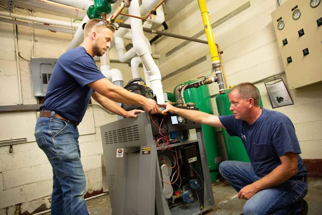 heating-FurnaceReplacement-Supporting-1100×734 Two HVAC technicians performing a furnace replacement service